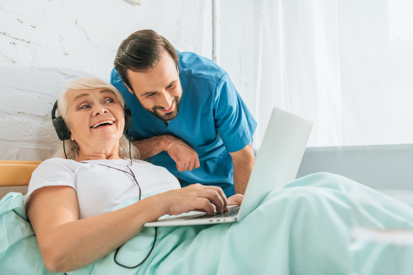 smiling doctor looking at happy senior woman in headphones using How To Lower Senior's Discomfort With Personal Care Communities Near Landsdale, PA