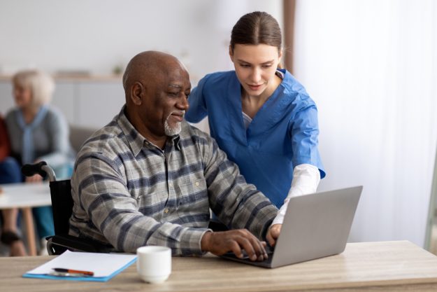 Young woman nurse helping black senior man using laptop Understanding Personal Care Services In PA