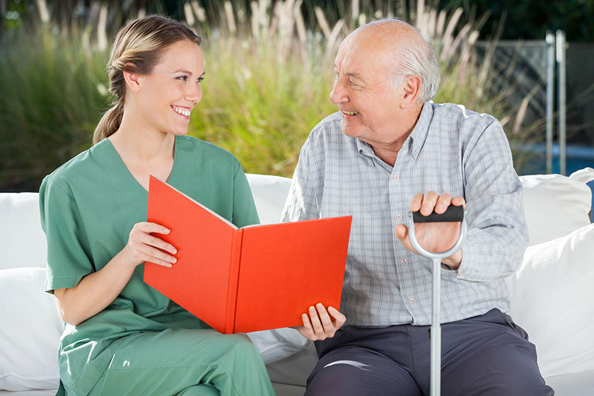 Smiling Female Nurse And Senior Man Looking At each other Smiling Female Nurse And Senior Man Looking At each other