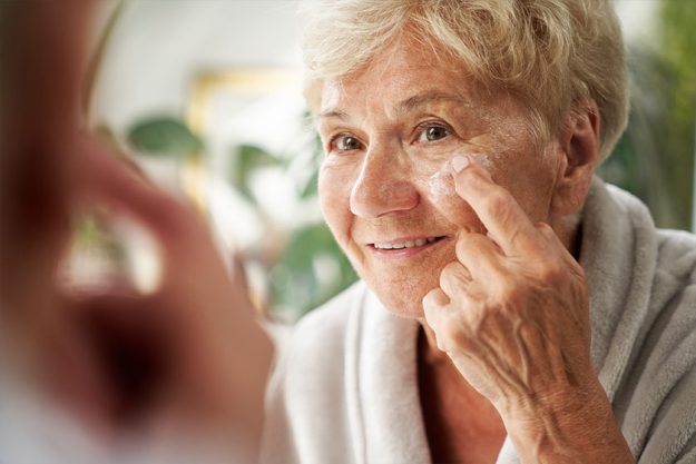 Senior woman applying a face cream Senior woman applying a face cream