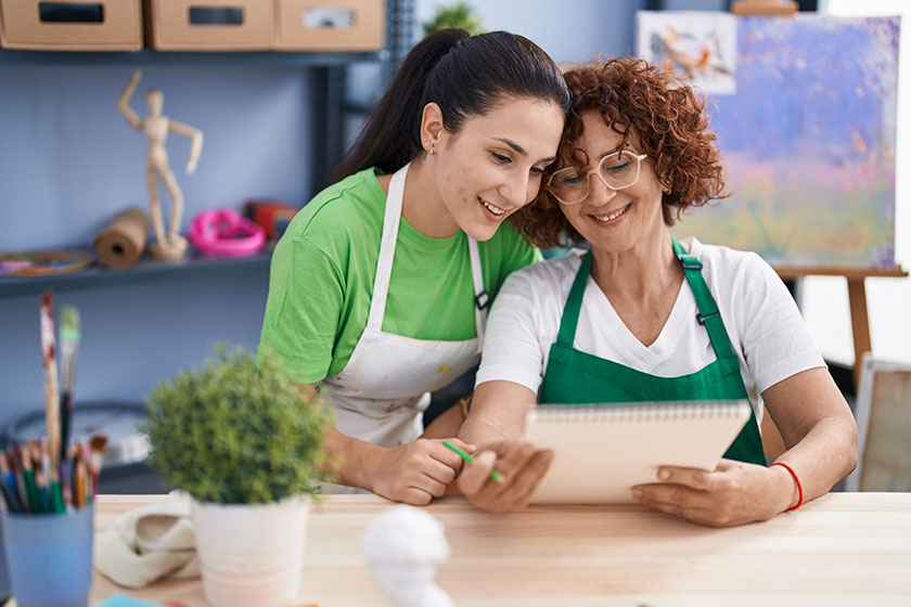 Two women artists drawing on notebook at art studio