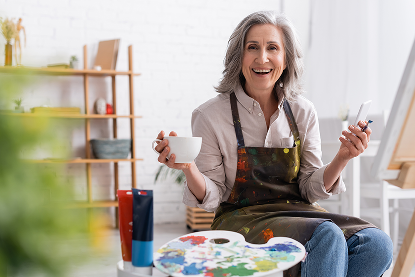 happy-middle-aged-artist-holding-paintbrush happy-middle-aged-artist-holding-paintbrush