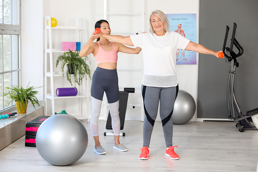 mature-woman-training-dumbbells-therapist mature-woman-training-dumbbells-therapist