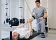 doctor-pulling-right-leg-of-pensioner-with-attached-resistance-band