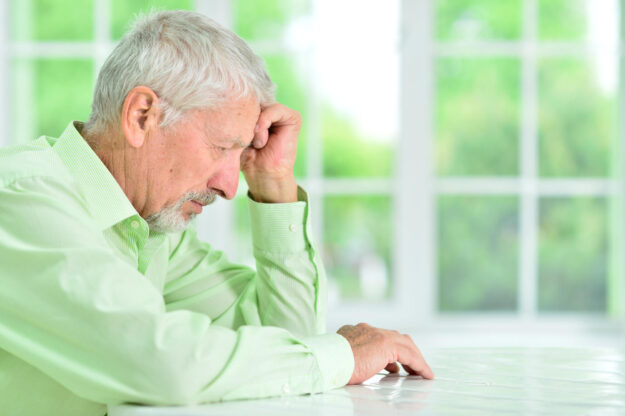 close-up portrait of a senior man thinking about something